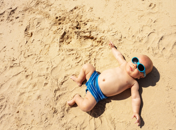 躺在海滩沙滩上的小婴儿图片下载