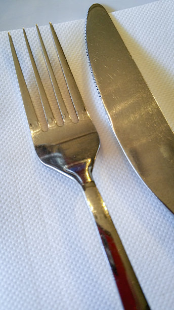 不锈钢刀叉餐具放在白纸餐巾上图片下载