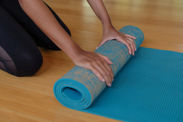 亚洲女人运动后卷起瑜伽垫图片下载
