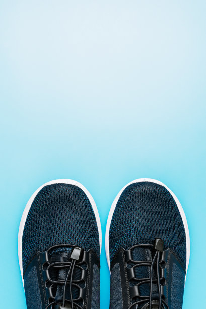 越野运动的概念：蓝色背景上的健身跑鞋，健康生活方式的简约象征图片下载