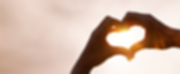 逆光下带有模糊效果的心形手图片下载