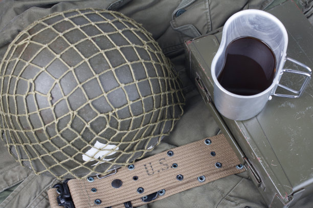 一杯咖啡与二战时期的美军军事装备上的绿色制服图片下载