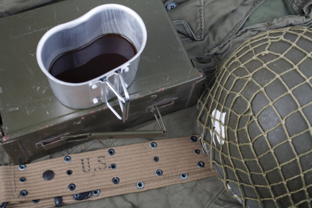 一杯咖啡与二战时期的美军军事装备上的绿色制服图片下载