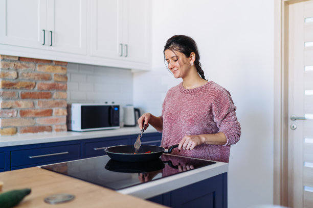 在厨房里煎菜的女人图片下载