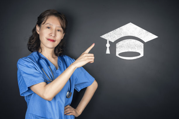 美丽年轻亚洲医生指向黑板上的学士帽图片下载
