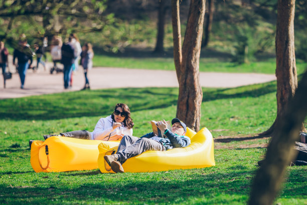 情侣在公园充气床垫上看书喝冰沙图片下载