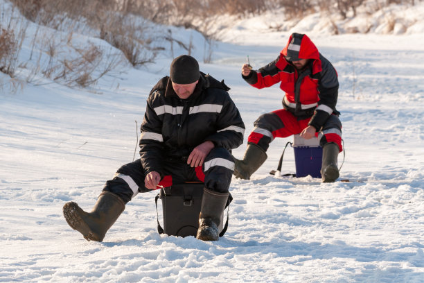 两个渔民在冬天的河里钓鱼，特写。图片下载