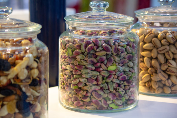 白色木桌上玻璃罐中的各种坚果和种子。素食和有机食品的概念。图片下载