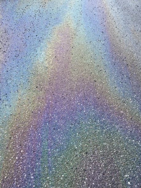 柏油路上有彩虹色的油渍图片下载