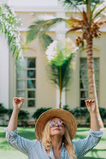 戴着帽子的旅行美女在棕榈树后做瑜伽的肖像。阳光。旅行、度假、梦想概念图片下载