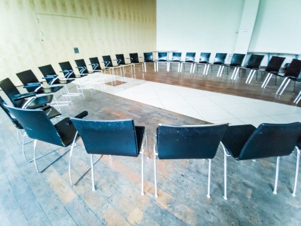 夜晚，绿色草地上围成一圈的黑色椅子。浅景深。图片下载