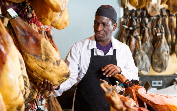 普通商店店主检查火腿质量图片下载