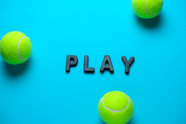 明亮蓝色背景上的网球和文字“play”图片下载
