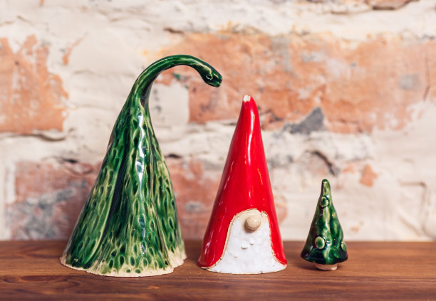 陶瓷侏儒，圣诞树在砖墙背景。手工制作的图片下载