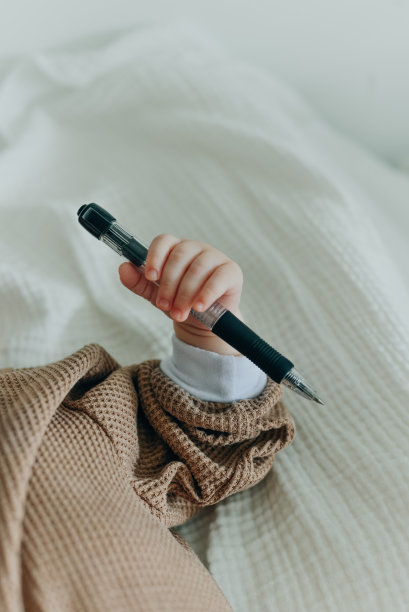 儿童手握黑色钢笔图片下载