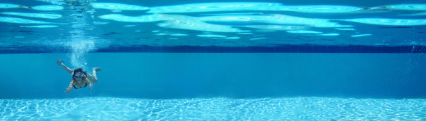 年轻女子在游泳池跳水图片下载