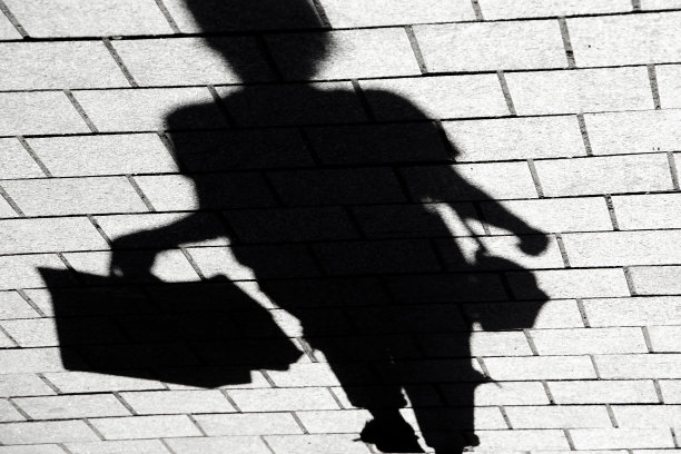 模糊的影子剪影一个年轻的女人走在购物袋图片下载