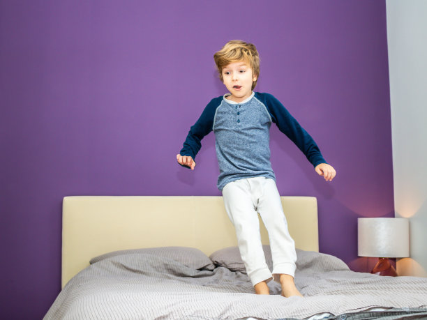 在床上跳跃的可爱小朋友图片下载