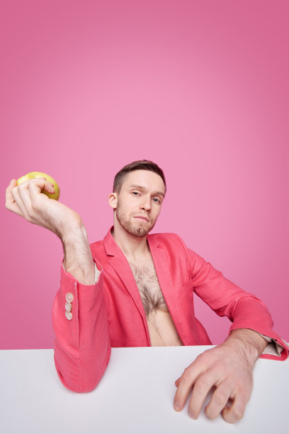 英俊的年轻人放松的男人在红夹克拿着苹果或其他一些水果图片下载