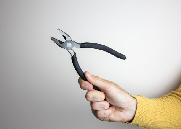 在空白背景上，男人穿着黄色毛衣，手持钳子的样机图片图片下载