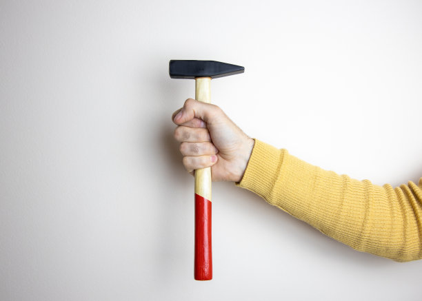 穿着黄色毛衣的男子手持锤子的样机图片图片下载