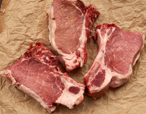 肋排上的三片生多汁的猪肉图片下载