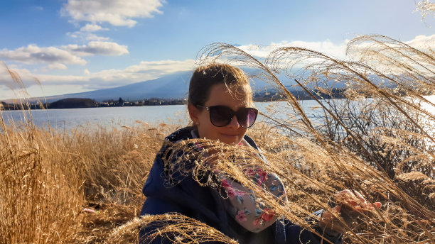 日本——一个女孩走在金色的草地和后面的富士山之间图片下载