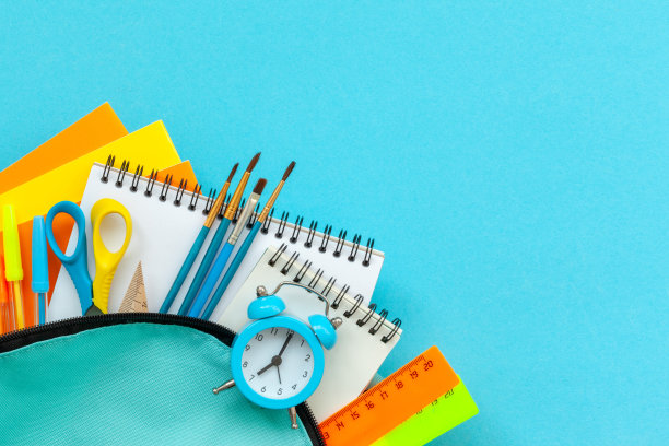 概念回到学校。全绿松石学校背包与用品在蓝色的背景。平的。图片下载