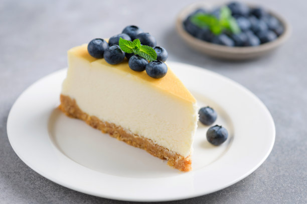 一片普通的芝士蛋糕，上面点缀着新鲜的蓝莓图片下载