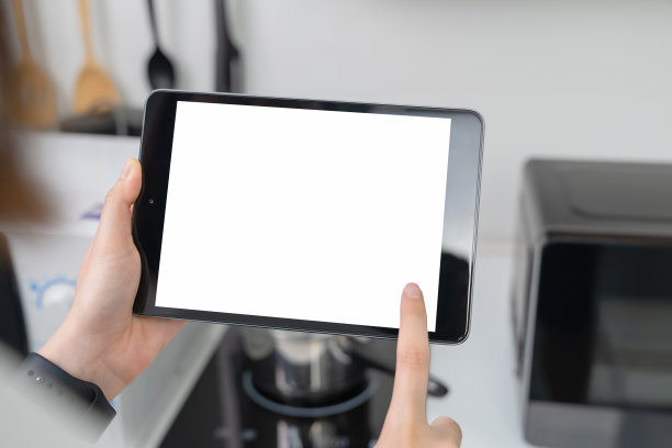 在家中厨房手持平板电脑特写图片下载