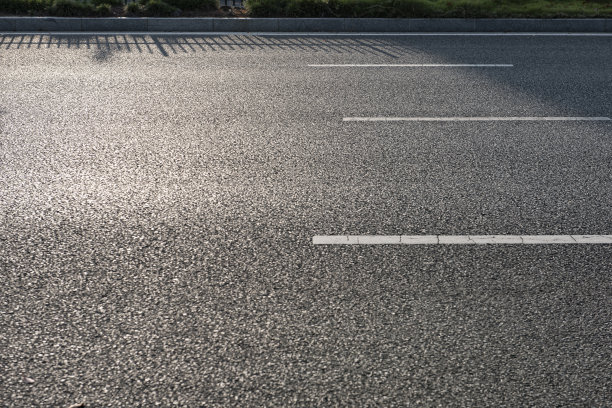 城市柏油马路和行道树的映照，高层住宅建筑在远处的行道树后面图片下载