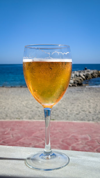 海滩酒吧的桌子上放着一杯啤酒图片下载