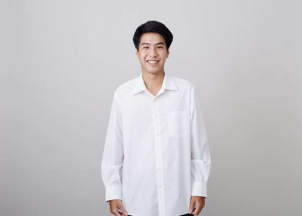 年轻的亚洲英俊商人墙上灰色的背景图片下载