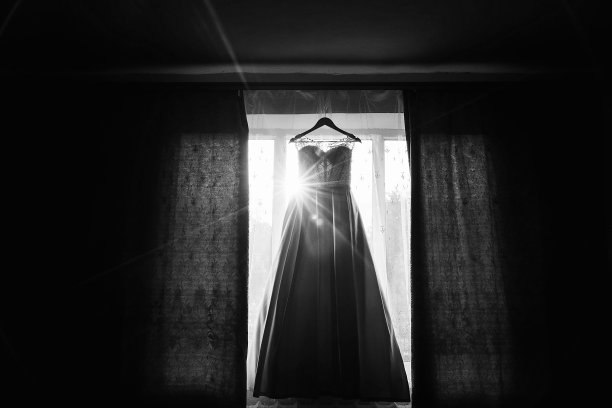 清晨阳光下挂在窗边衣架上的漂亮婚纱图片下载