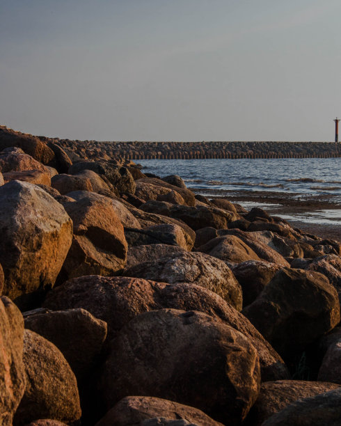 在一个朦胧的夏日，防波堤的石头。图片下载