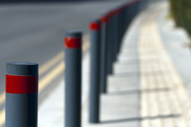一排灰色的带有红色条纹的街道护柱图片下载