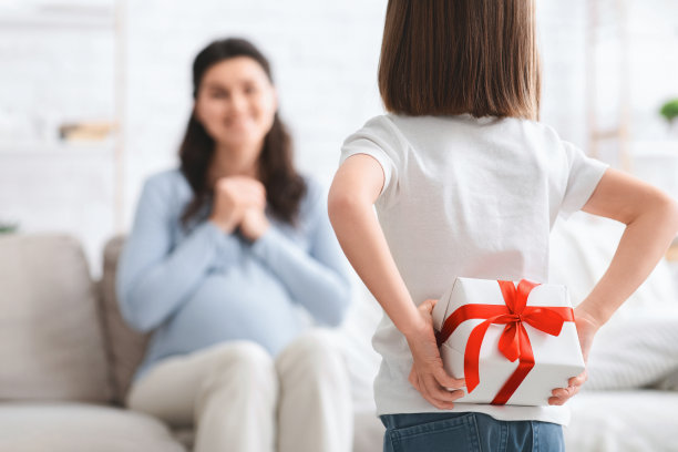 小女孩拿着礼物盒，母亲的背影图片下载