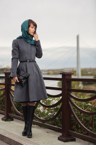 年轻的时尚女性在灰色的经典外套和头巾图片下载