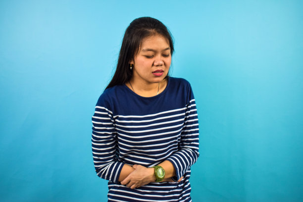 年轻美丽的亚洲妇女的肖像与蓝色孤立的背景图片下载