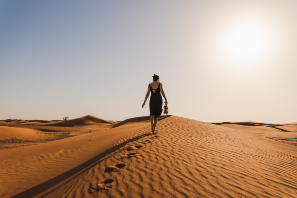 女人登上红色沙丘顶端图片下载