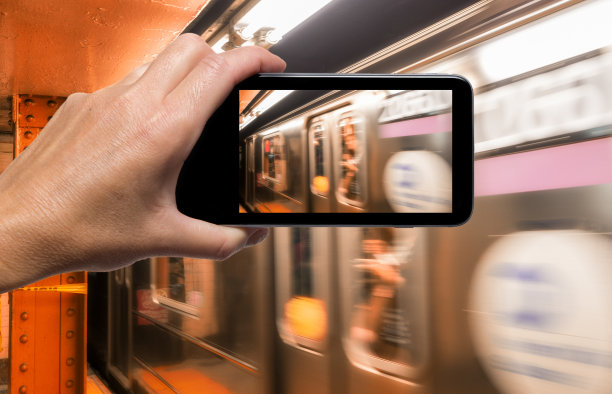 用智能手机拍摄纽约地铁列车的女人手，旅游概念图片下载