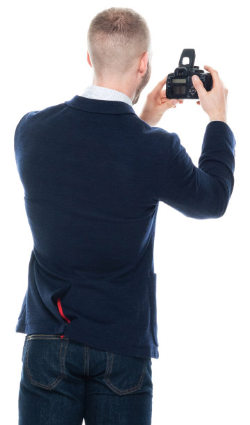 白人男性游客身穿商务休闲装，手持相机站在白色背景前图片下载