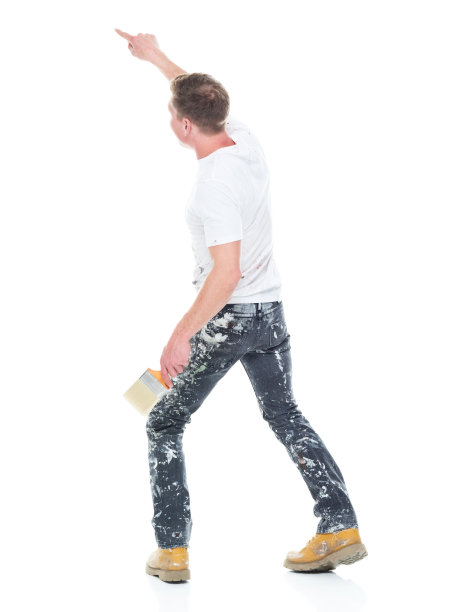 白人男性画家站在白色背景前，拿着画笔图片下载