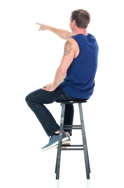 白人男性无袖坐在白色背景前穿裤子图片下载