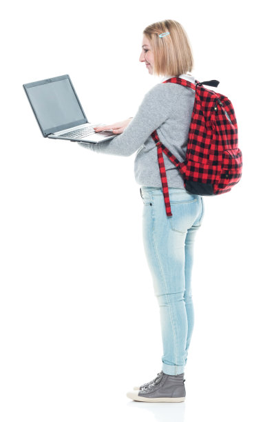 z一代女高中生穿着牛仔裤，拿着包，站在白色背景前使用电脑图片下载