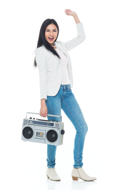 拉丁美洲和西班牙裔的年轻女性站在前面的白色背景穿着时髦的休闲装和拿着扬声器图片下载
