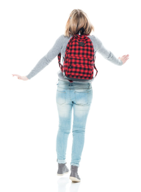 z一代少女初中生穿着暖和的衣服拿着包在白色背景前跳舞图片下载