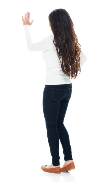 拉丁美洲和西班牙裔的年轻女性穿着牛仔裤站在白色背景前图片下载