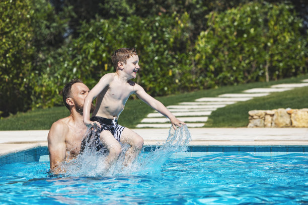 父亲和儿子在游泳池里跳图片下载