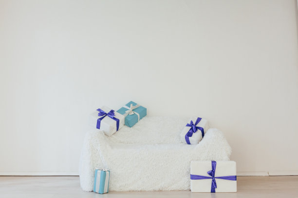 蓝色的礼物放在沙发内部，白色的房间装饰假日图片下载